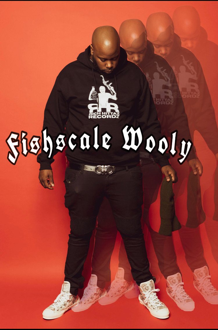 Fishscale Wooly in a Rich Hittaz Recordz hoodie against a red wall, with an echo trail.